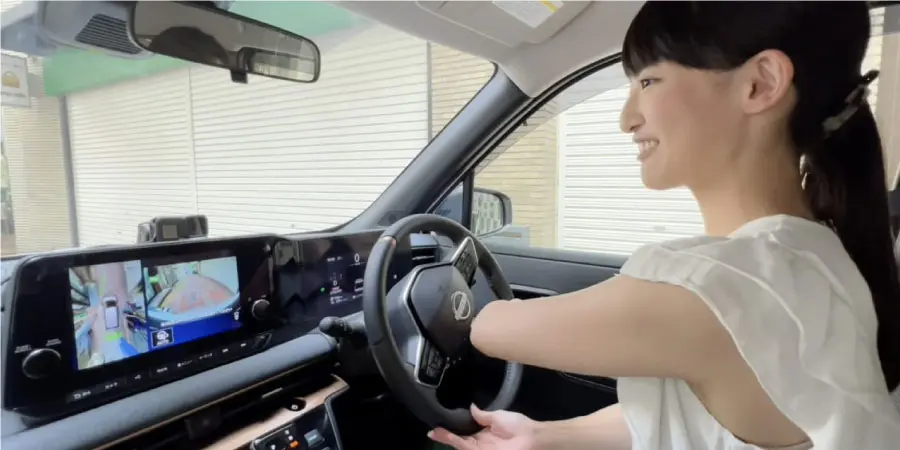 ニッサンサクラ モニターを見ながら運転する女性 バックモニター設置イメージ