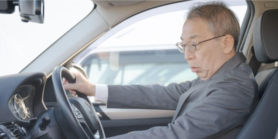 操作を確認しながら運転する男性