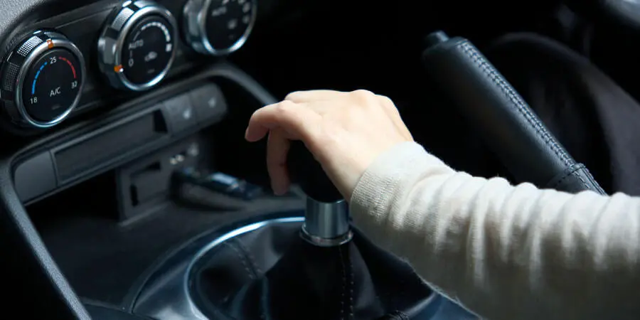 マニュアル車のシフトレバー操作する女性の手