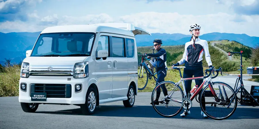 エブリイワゴンから自転車を降ろしている男女