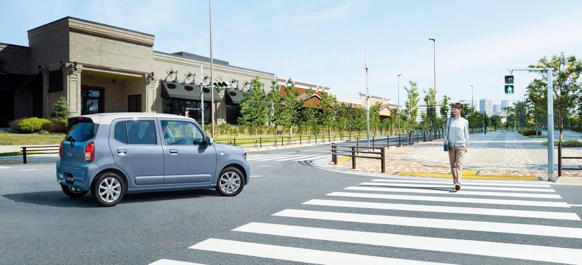 交差点で停車するアルトと横断歩道をわたる歩行者