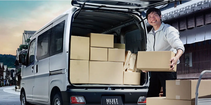 ハイゼットカーゴにリアゲートから荷物を積み込む男性