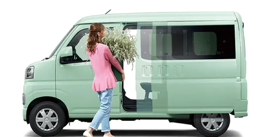 ハイゼットカーゴにスライドドアから荷物を積み込む女性